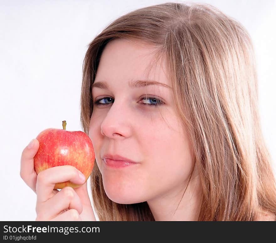 A studio shot of a beautiful girl holding an apple in her hand, isolated on white background. A studio shot of a beautiful girl holding an apple in her hand, isolated on white background