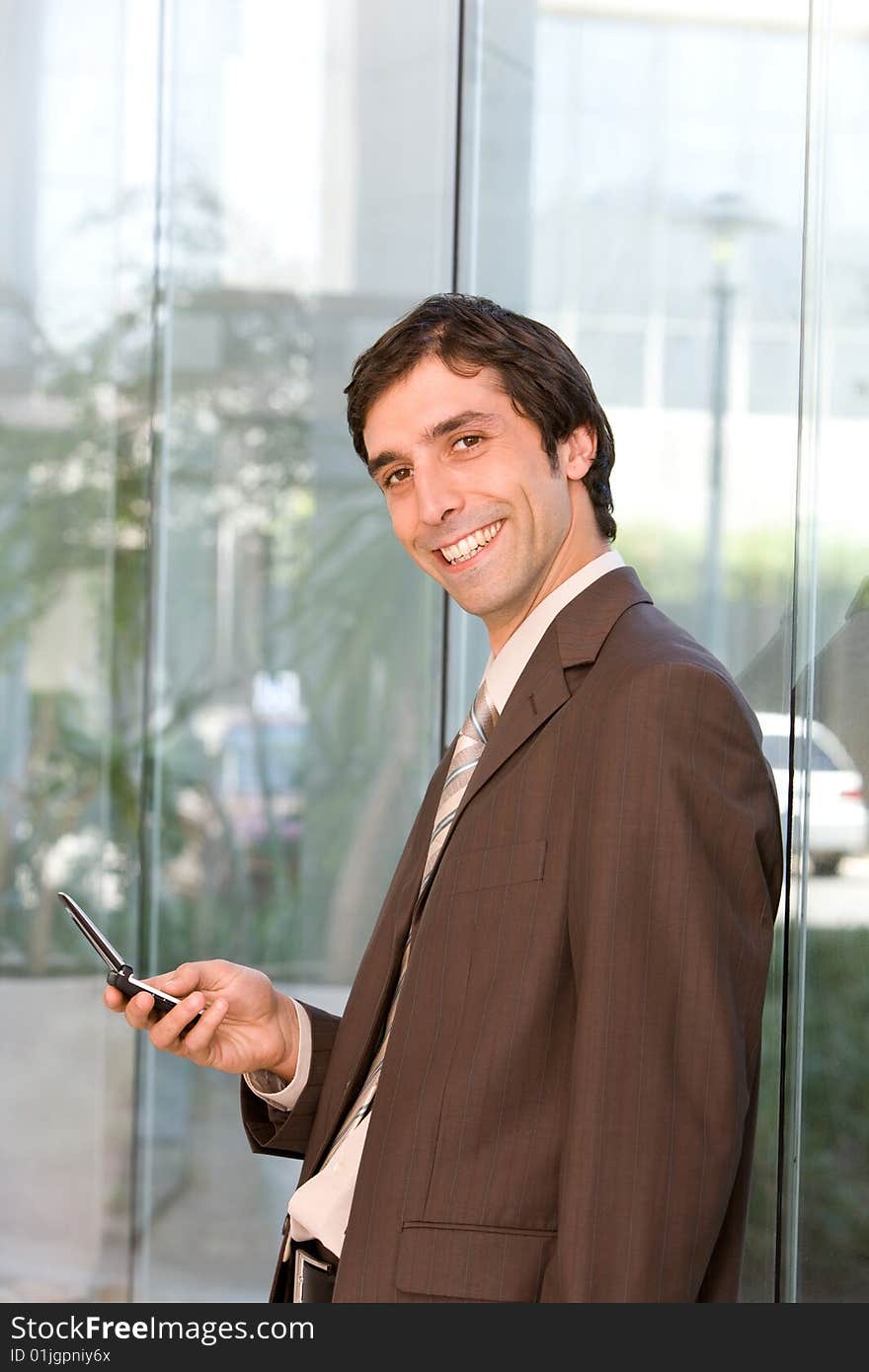 Portrait of confident smiling business man holding cell phone.