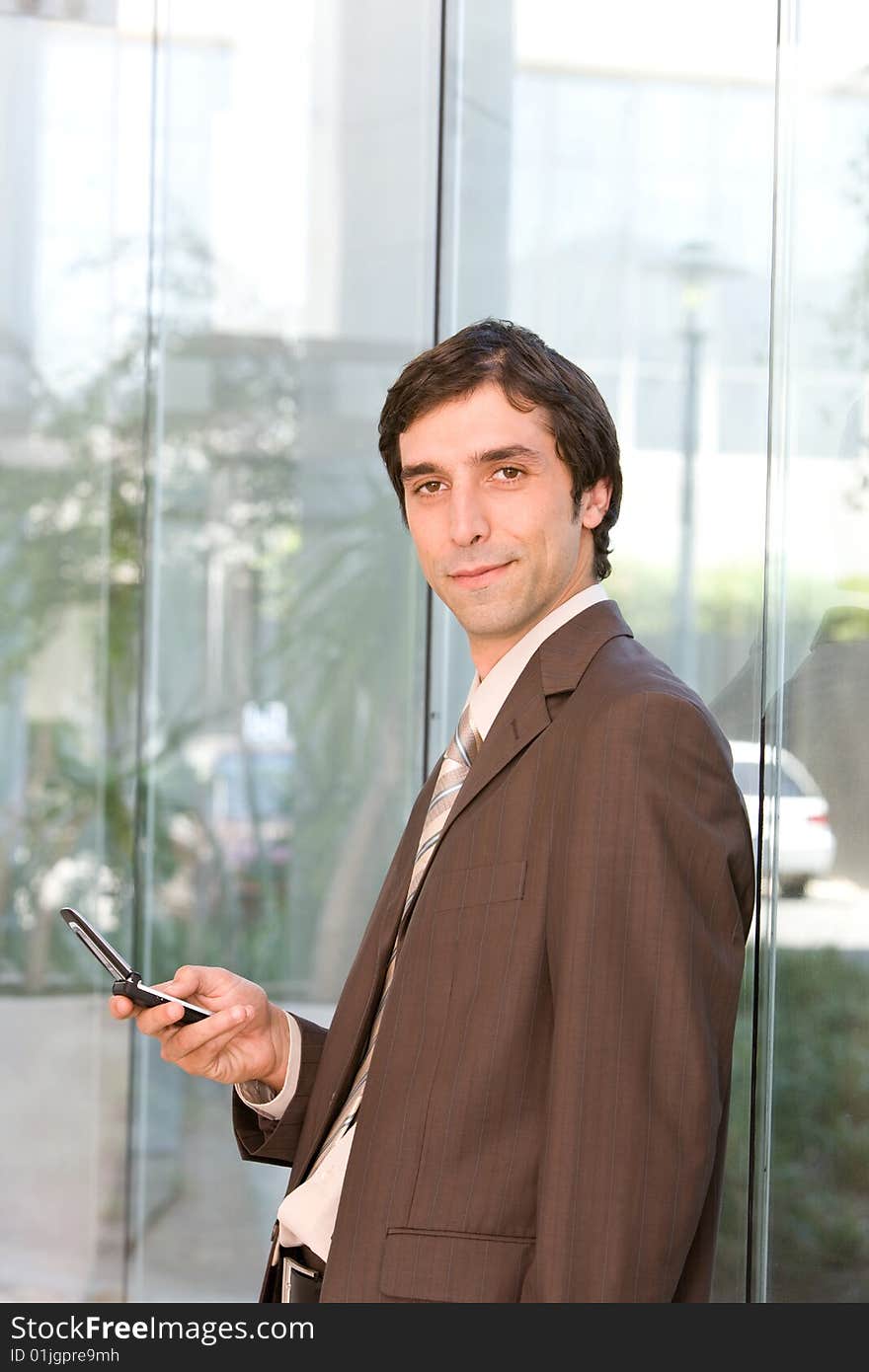 Portrait of confident business man holding cell phone.