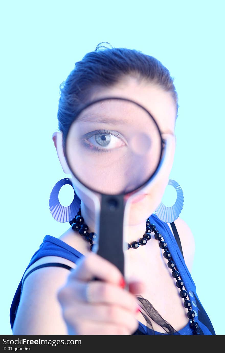 Eye of the girl in a magnifier covered by blue light