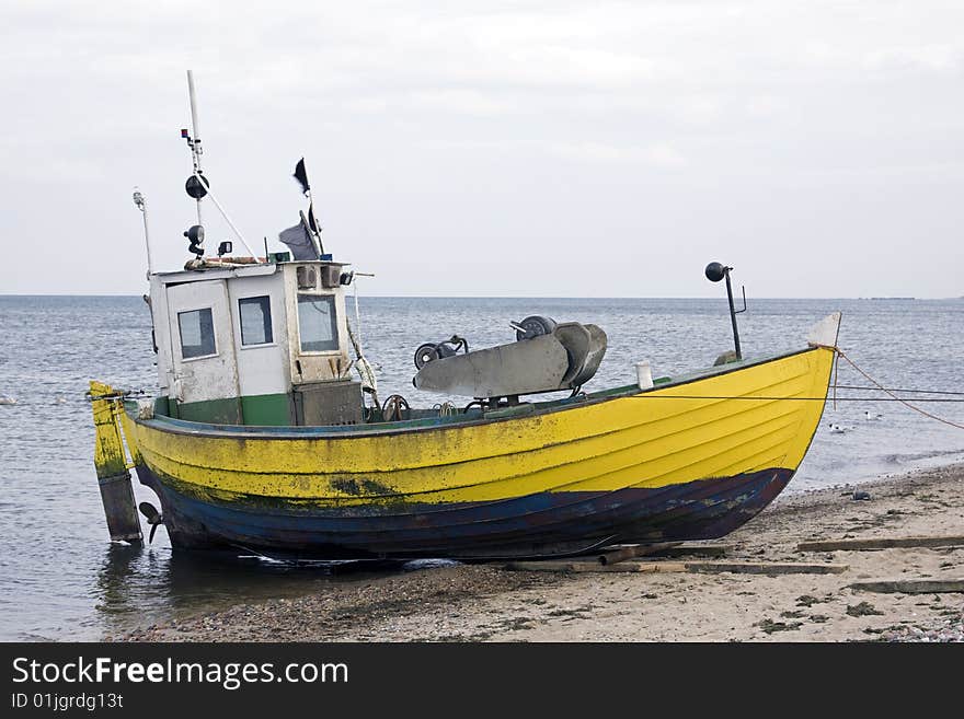 Yellow fisher boat on the seashore