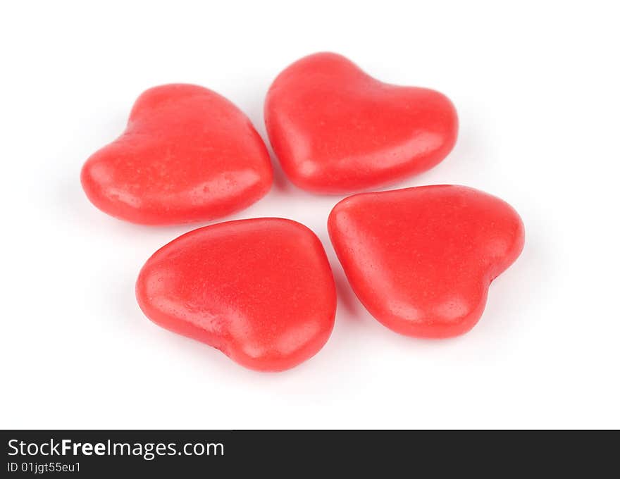 Four heart shaped candies on a white background