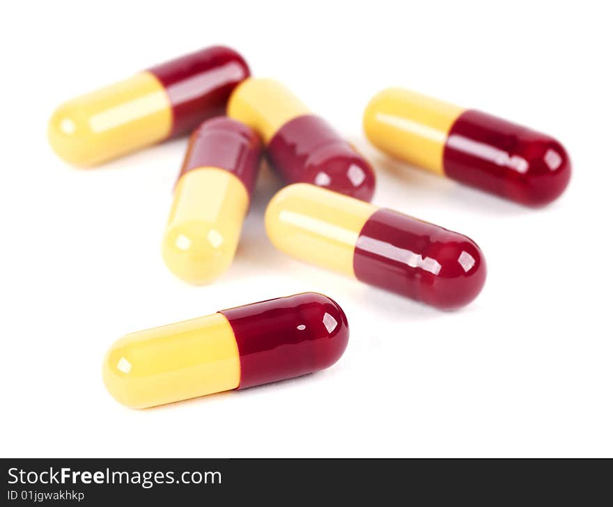 Several drug filled capsules on a white background