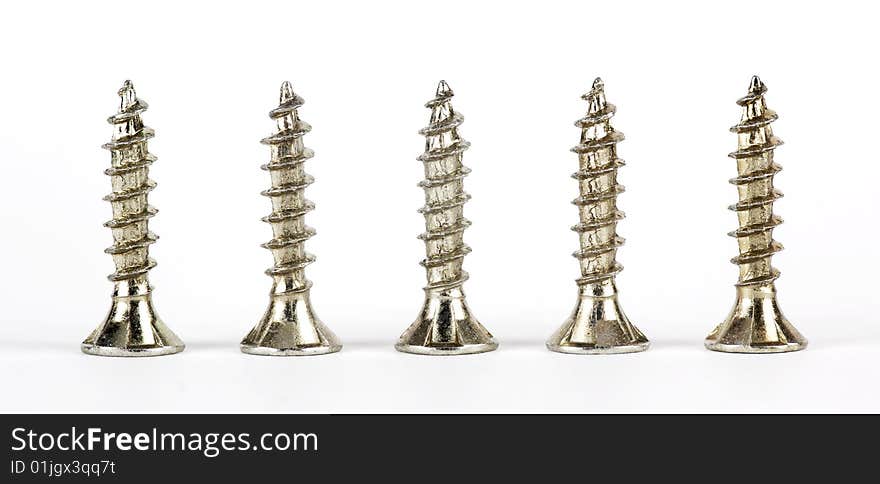 Metal screws in a row on a white background. Metal screws in a row on a white background