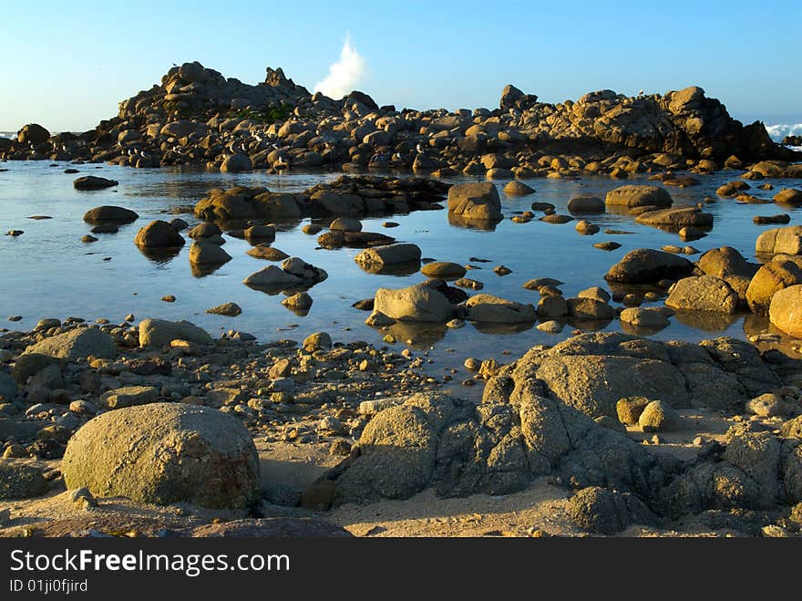 Waves crash behind a rocky island off the California Coast, giving the look of a blow hole of a whale. Waves crash behind a rocky island off the California Coast, giving the look of a blow hole of a whale