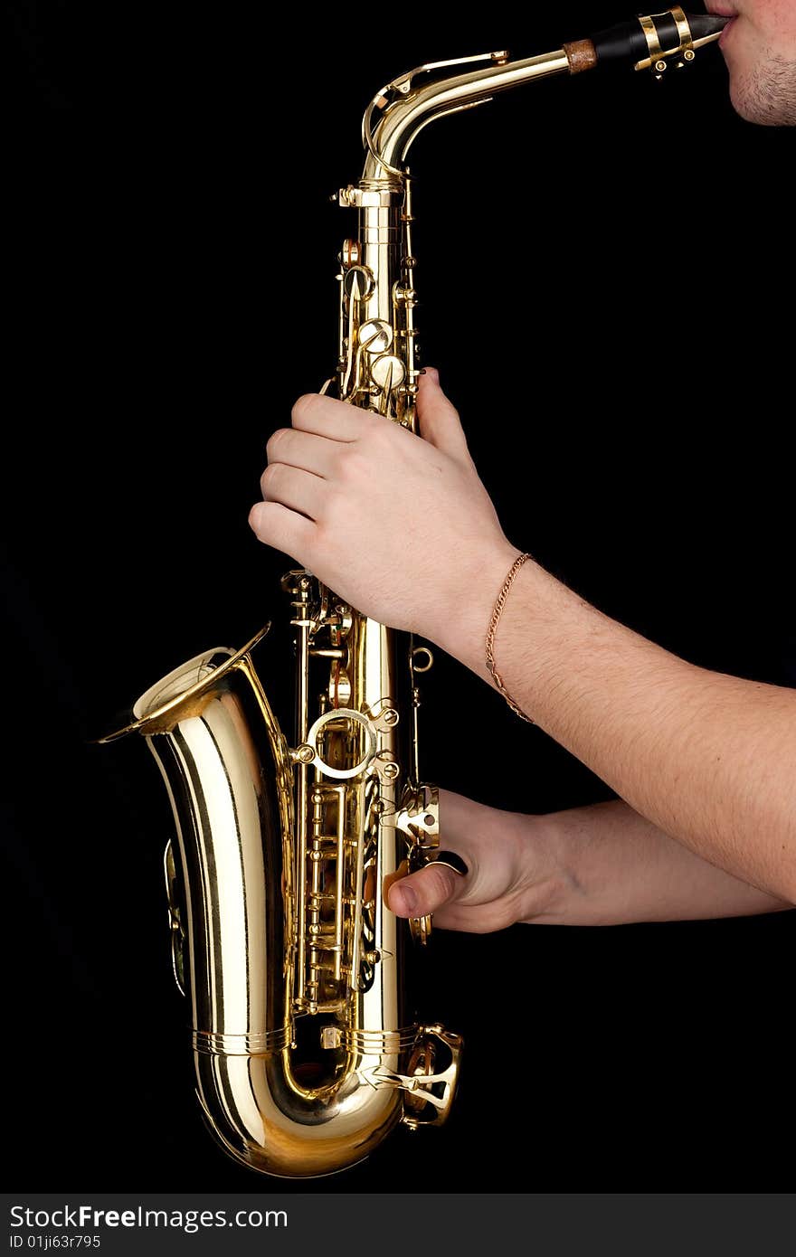 Golden alto saxophone in hands of young man