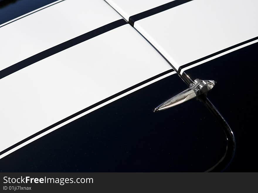 Hinge, hood and racing stripes of a classic sportscar. Hinge, hood and racing stripes of a classic sportscar.