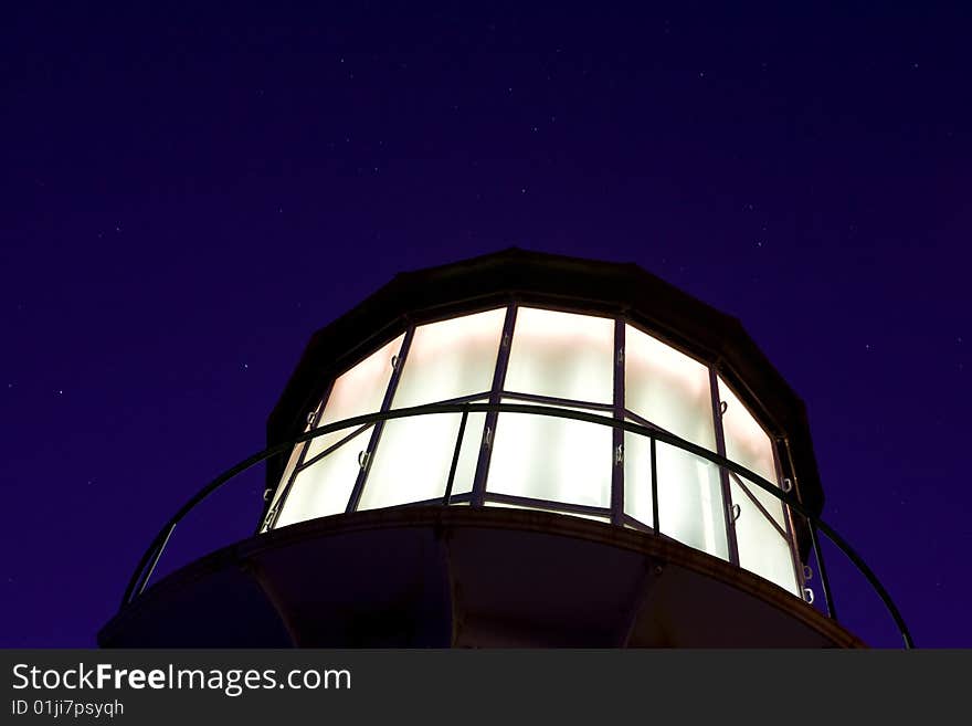 Fresnel lens lighthouse against a star filled sky