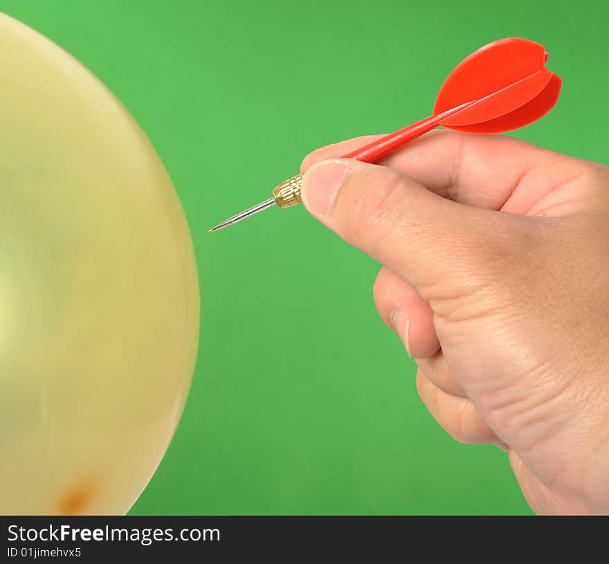 Hand dart punctured balloon,Green background. Hand dart punctured balloon,Green background