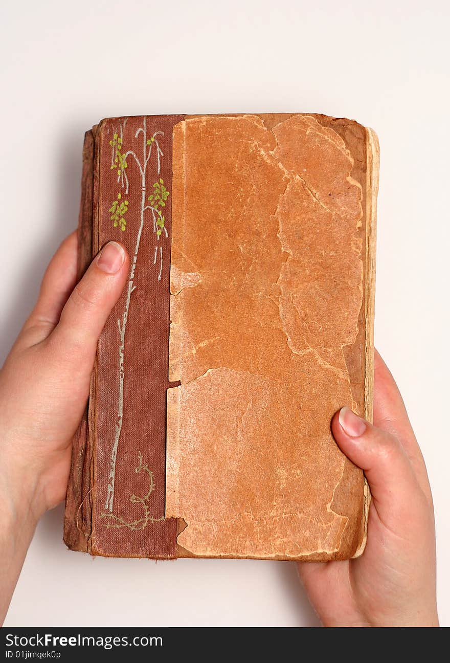 Aging book in hand on light background. Aging book in hand on light background.