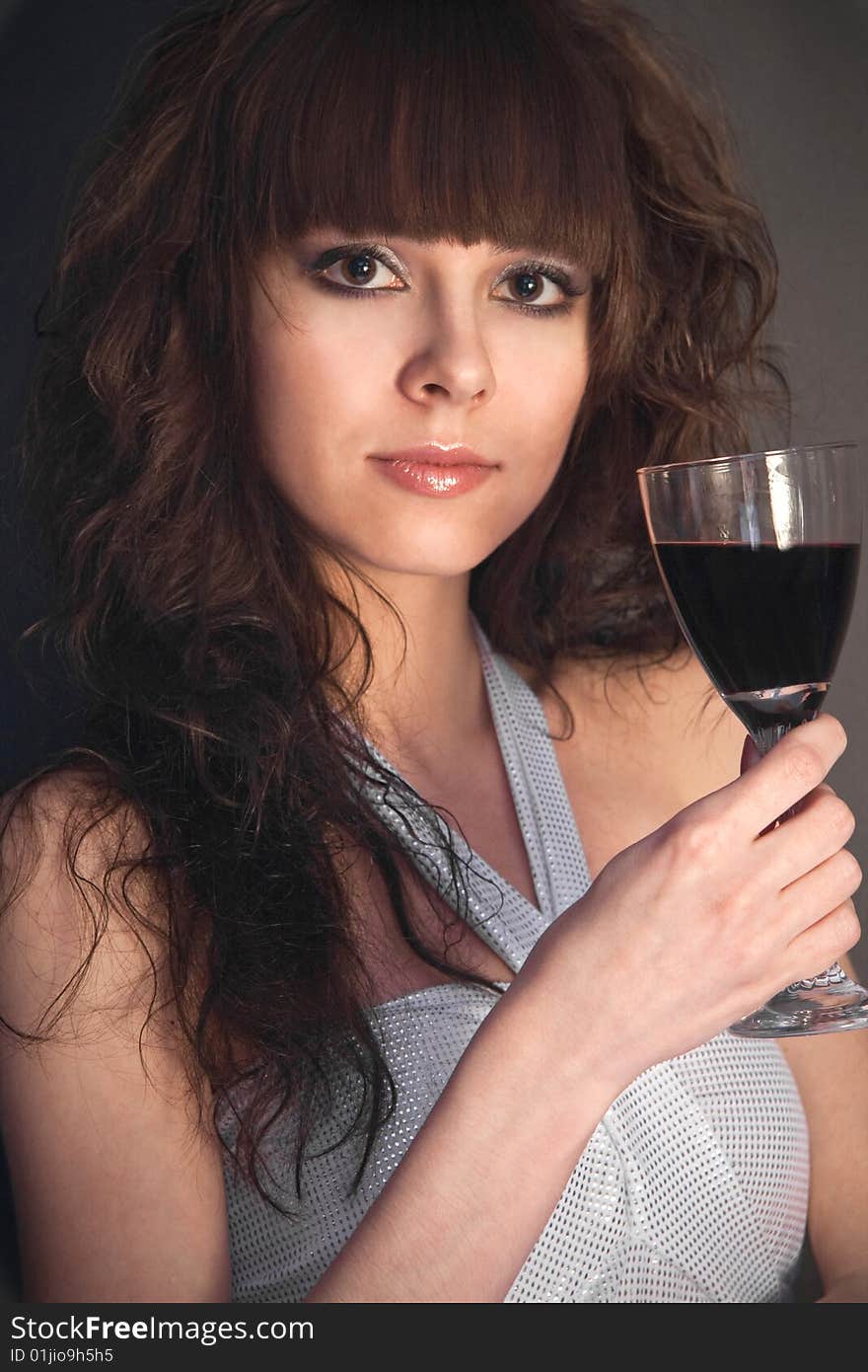 Beautiful girl with a wineglass on a black background