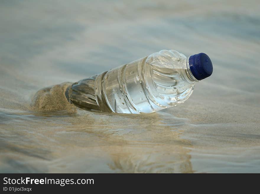 Plastic bottle in water on the sand beach. Plastic bottle in water on the sand beach