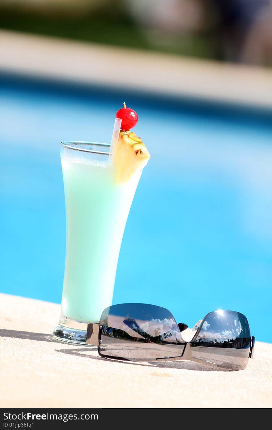 Cocktail with sunglasses on the edge of the swimming pool. Cocktail with sunglasses on the edge of the swimming pool