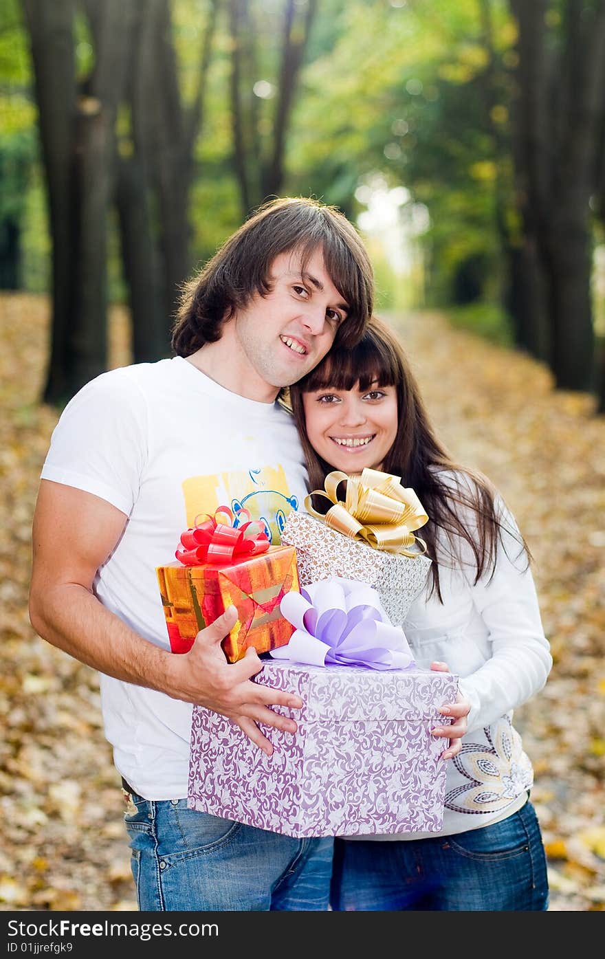 Young couple with gift boxes outside