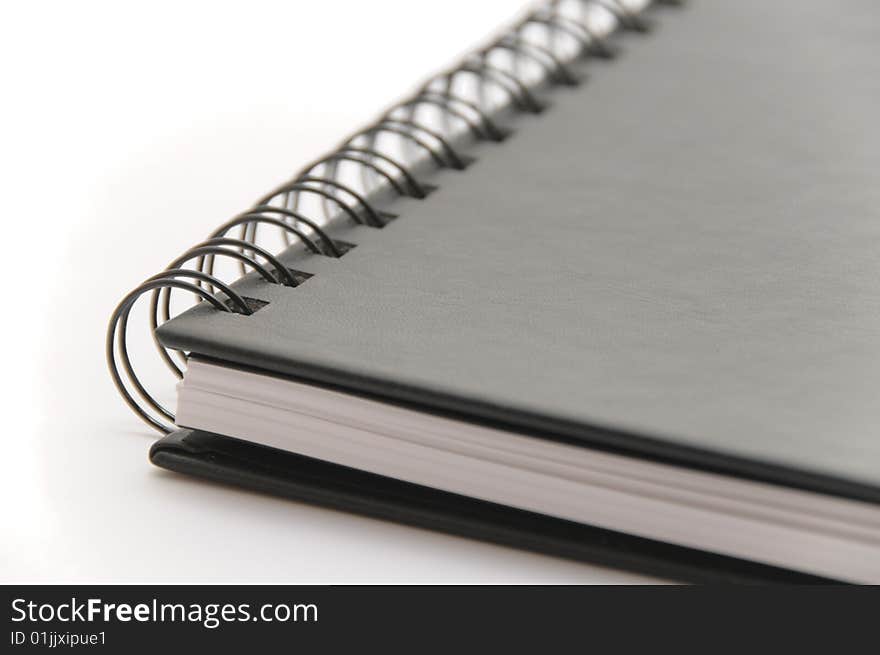 Black spiral notebook on white background