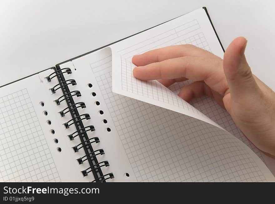 Hand turning page of blank spiral notebook (white background)