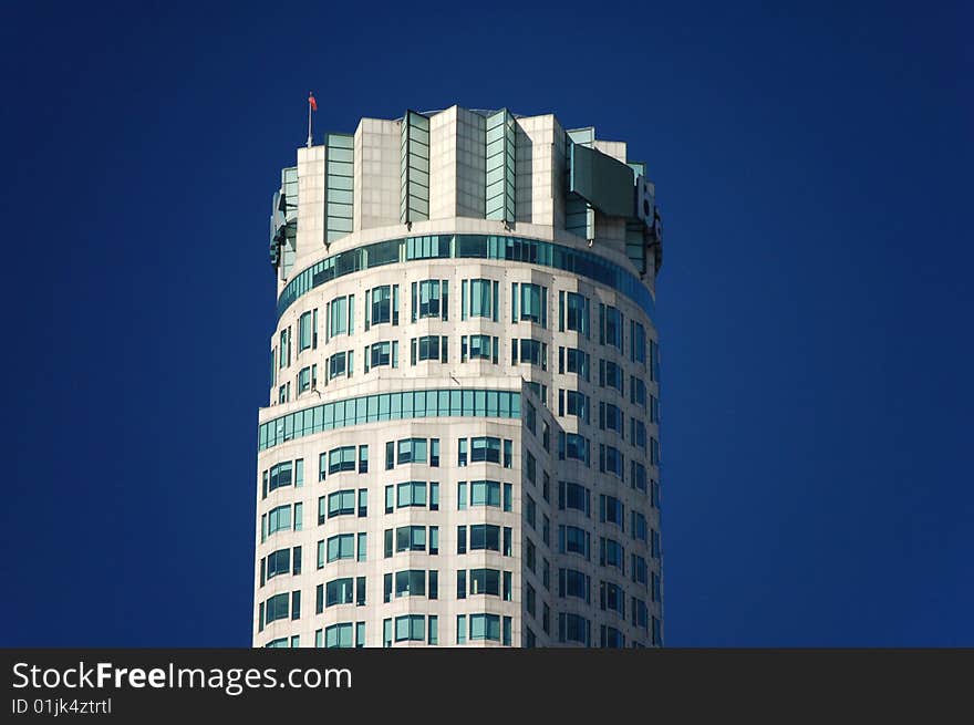 A modern high rise office building in a busy downtown area with a helicopter landing pad on the roof. A modern high rise office building in a busy downtown area with a helicopter landing pad on the roof.