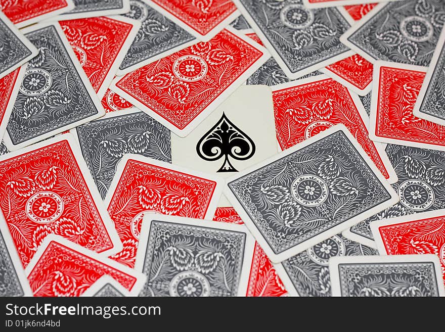 Ace of spades in the centre surrounded by red and grey playing cards