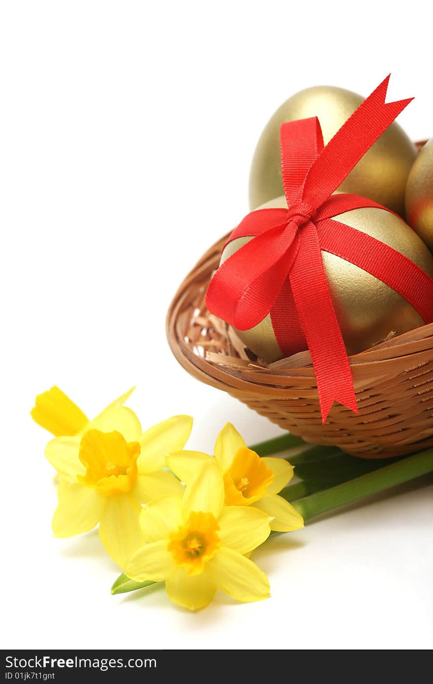 Golden egg wrapped around with red ribbon in basket with daffodils on white background. Golden egg wrapped around with red ribbon in basket with daffodils on white background.