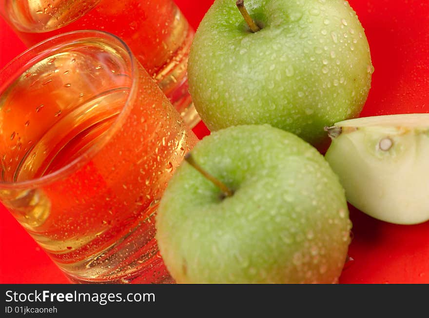 The big green apple with dewdrops on a red background. The big green apple with dewdrops on a red background