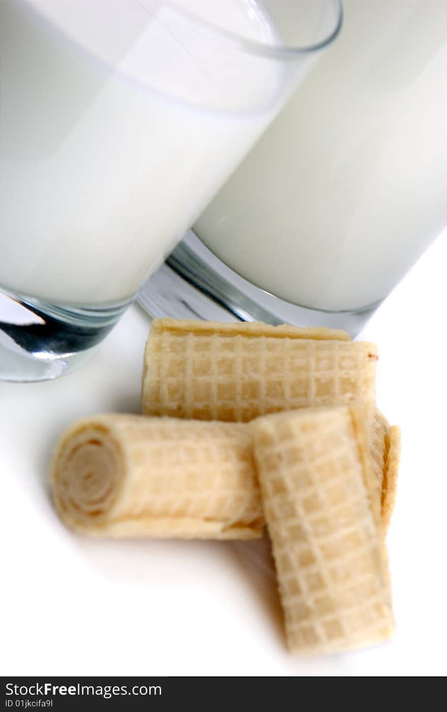 Glass of milk and fresh cookies on a white background