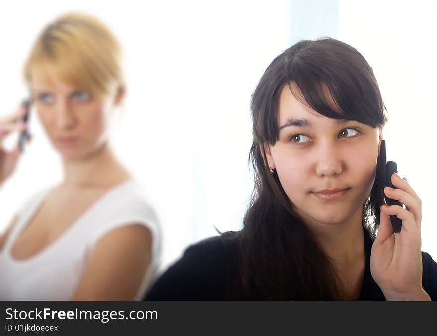 Two girls with mobile phones on the isolated