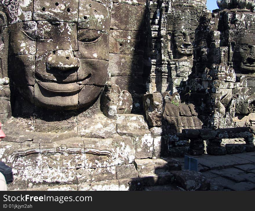 Ancient statues smile at pilgrims and tourists in Cambodia's Angkor Wat temple complex. Ancient statues smile at pilgrims and tourists in Cambodia's Angkor Wat temple complex.