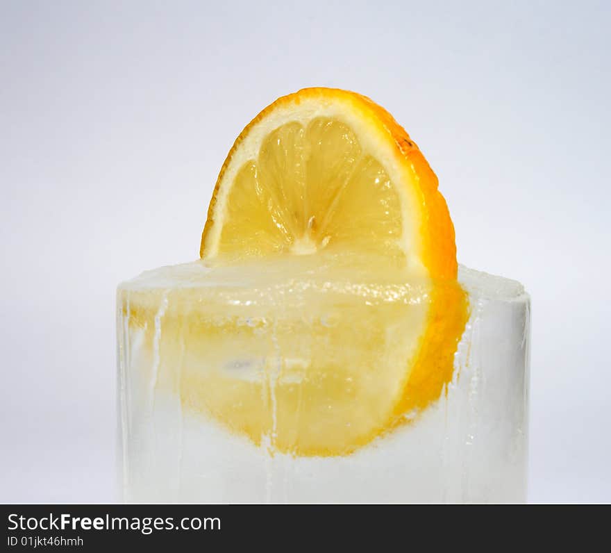 Lemon in ice on a white surface