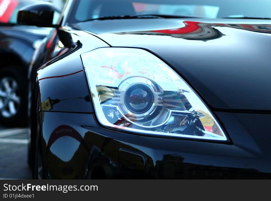 This black sports car was so shining you could see the reflections of the area. This black sports car was so shining you could see the reflections of the area.