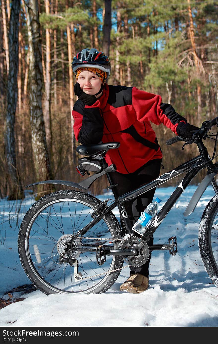 Girl with bike in the spring forest, last snow and sunny day