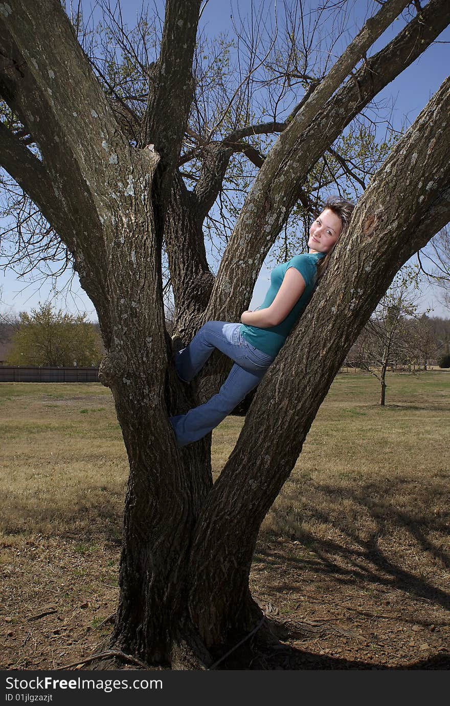 Teen girl relaxes in tree