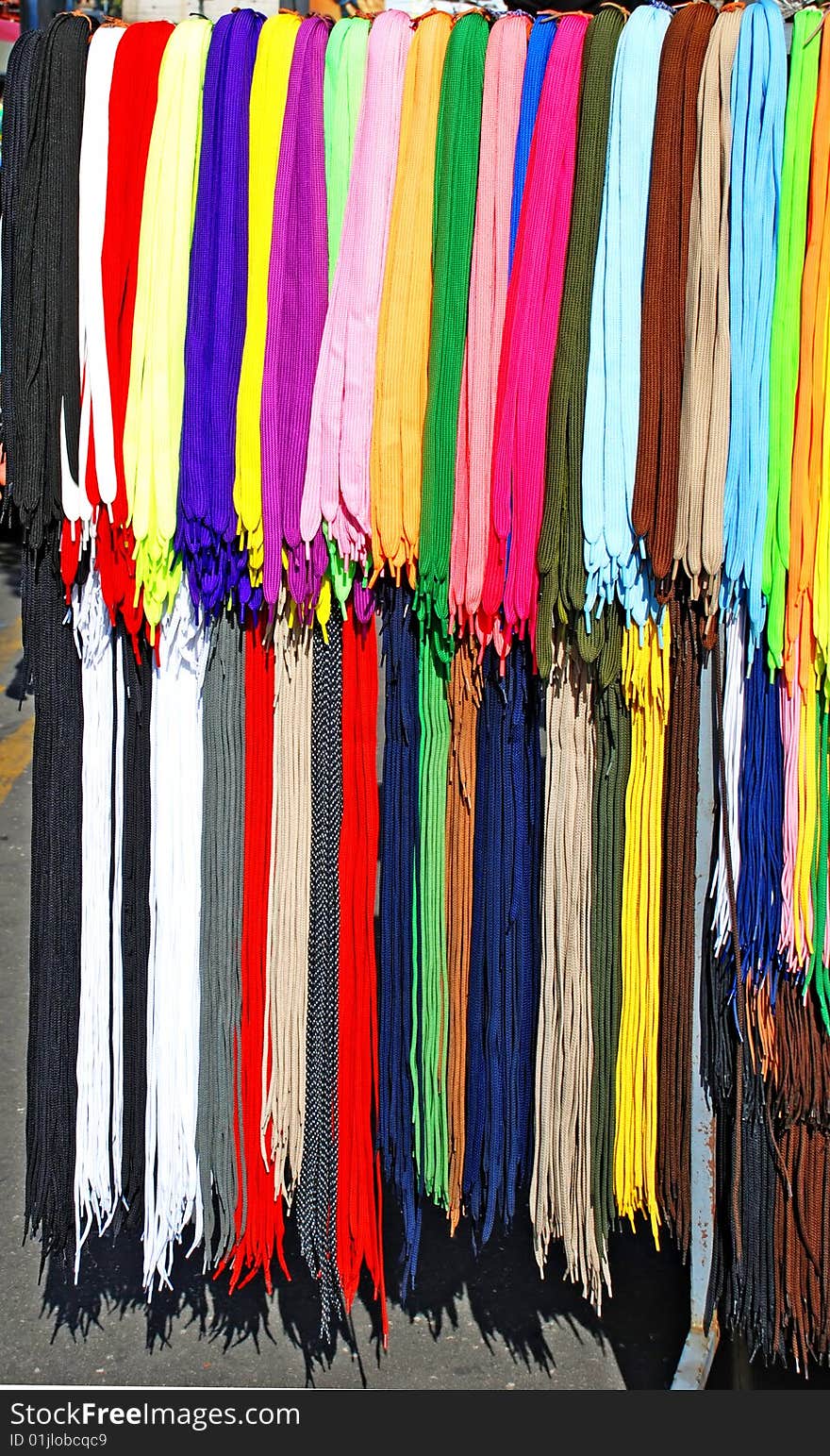 Multicolored new laces hanging in row on sale. Multicolored new laces hanging in row on sale