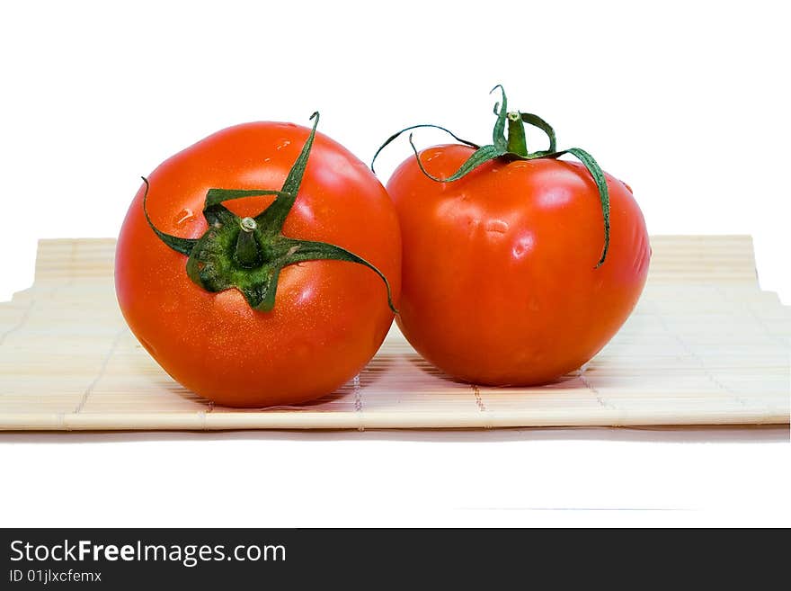 Two fresh tomatoes on a white background