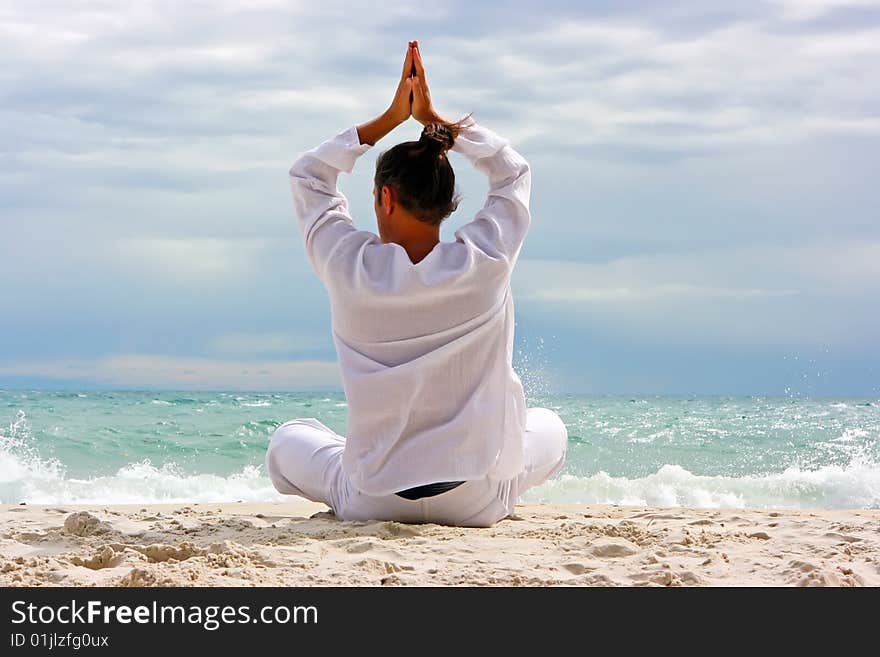 Young man practising yoga on the sandy beach. Young man practising yoga on the sandy beach