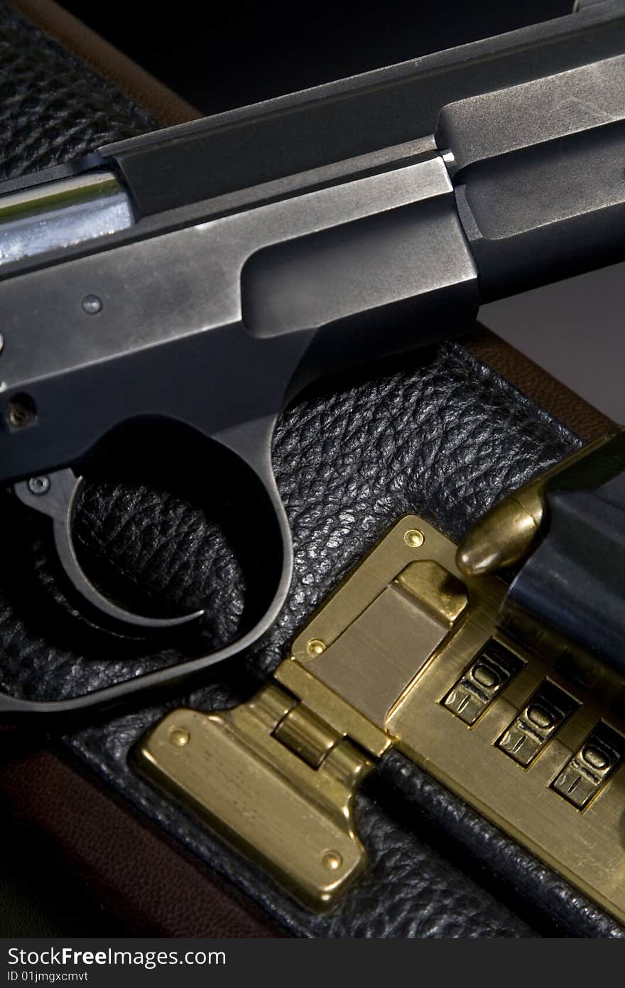 Pistol on the briefcase, black background