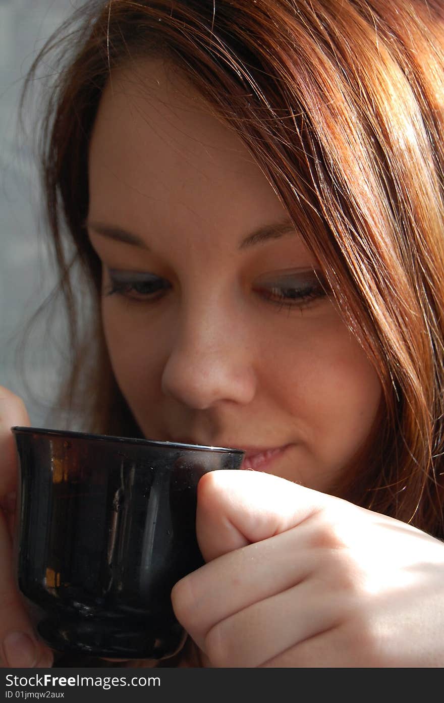 Beautiful young woman with black cup