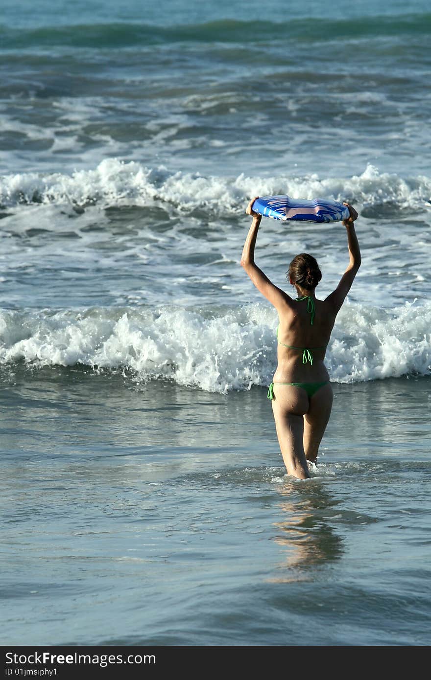 Bikini Girl with boogie board in water, waiting for the wave. Bikini Girl with boogie board in water, waiting for the wave