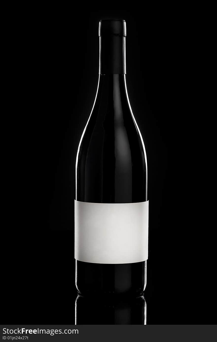 Red wine bottle over a black background with empty label