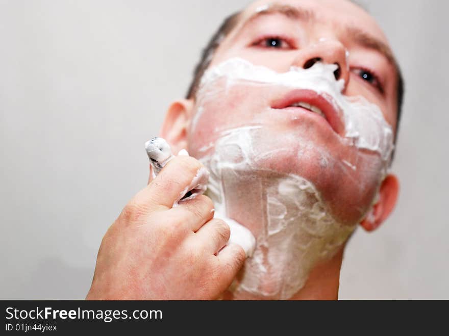 Man with razor against gray background. Man with razor against gray background