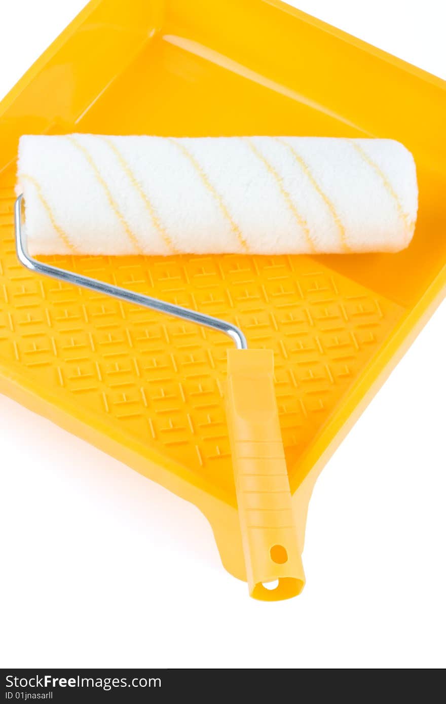 Paint roller in yellow paint tray over isolated white background. Paint roller in yellow paint tray over isolated white background