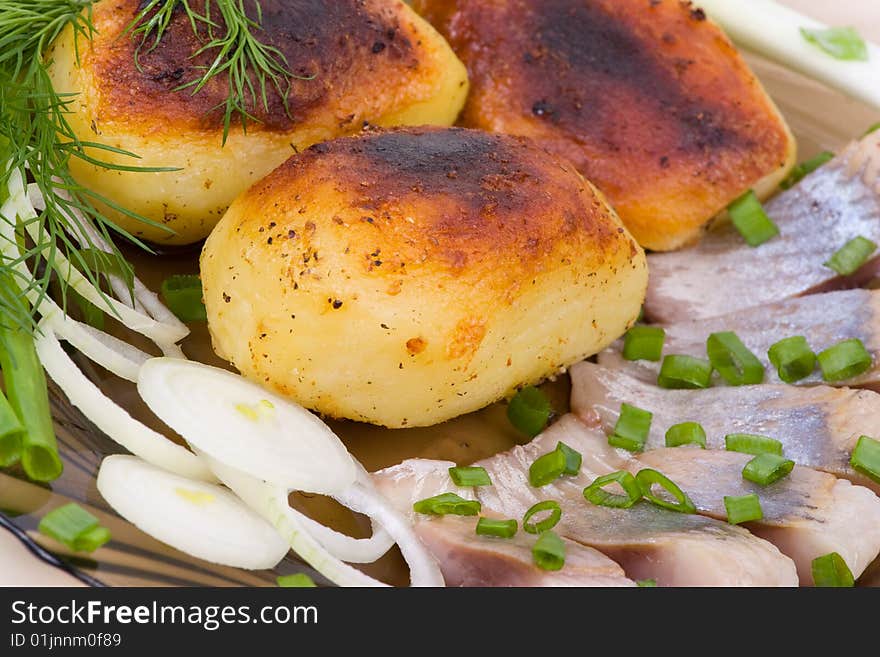 Baked potato with slices of a salty herring