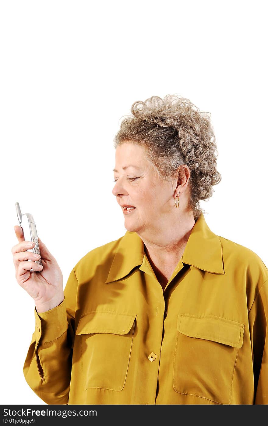 A senior woman in an dark yellow jacket dialing a number on her cell phone. On white background. A senior woman in an dark yellow jacket dialing a number on her cell phone. On white background.