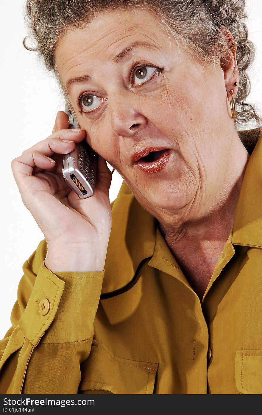 A senior woman in an dark yellow jacket talking on the
cell phone. On white background. A senior woman in an dark yellow jacket talking on the
cell phone. On white background.