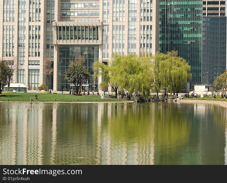 Office buildings, willows and their reflections in pond. shot at Pu dong, Shanghai in early spring. Office buildings, willows and their reflections in pond. shot at Pu dong, Shanghai in early spring.