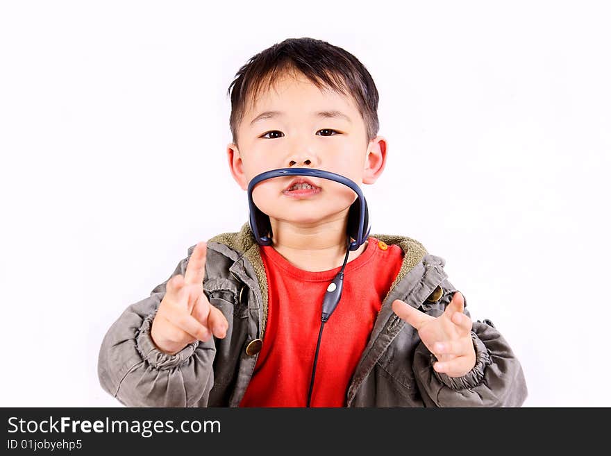 A picture of a little chinese boy listening to music with earphone, having great fun. A picture of a little chinese boy listening to music with earphone, having great fun