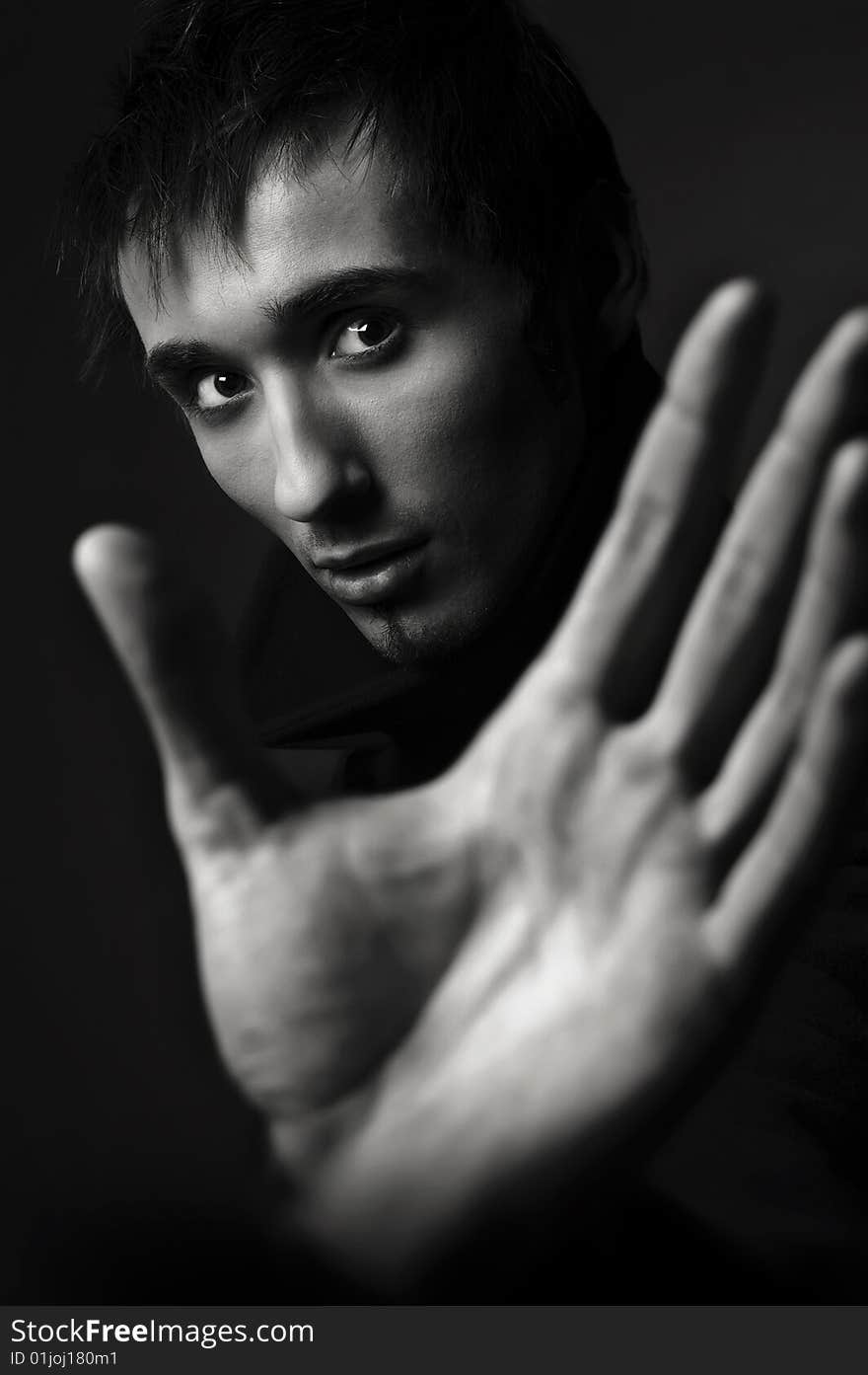 Portrait of a young business man with his hands on a dark background. Portrait of a young business man with his hands on a dark background