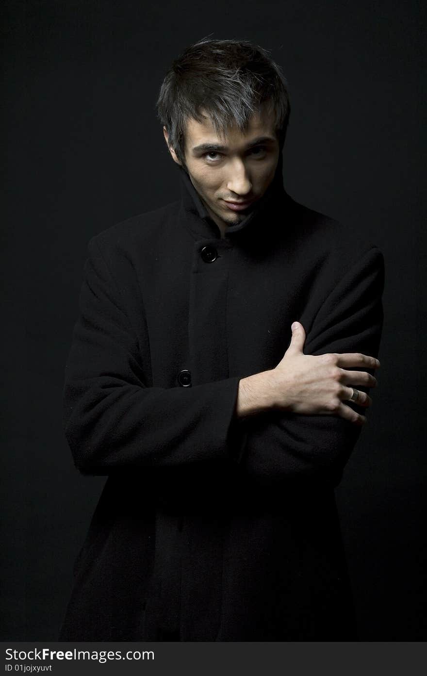 Portrait of a young business man with his hands looking strangeon a dark background. Portrait of a young business man with his hands looking strangeon a dark background