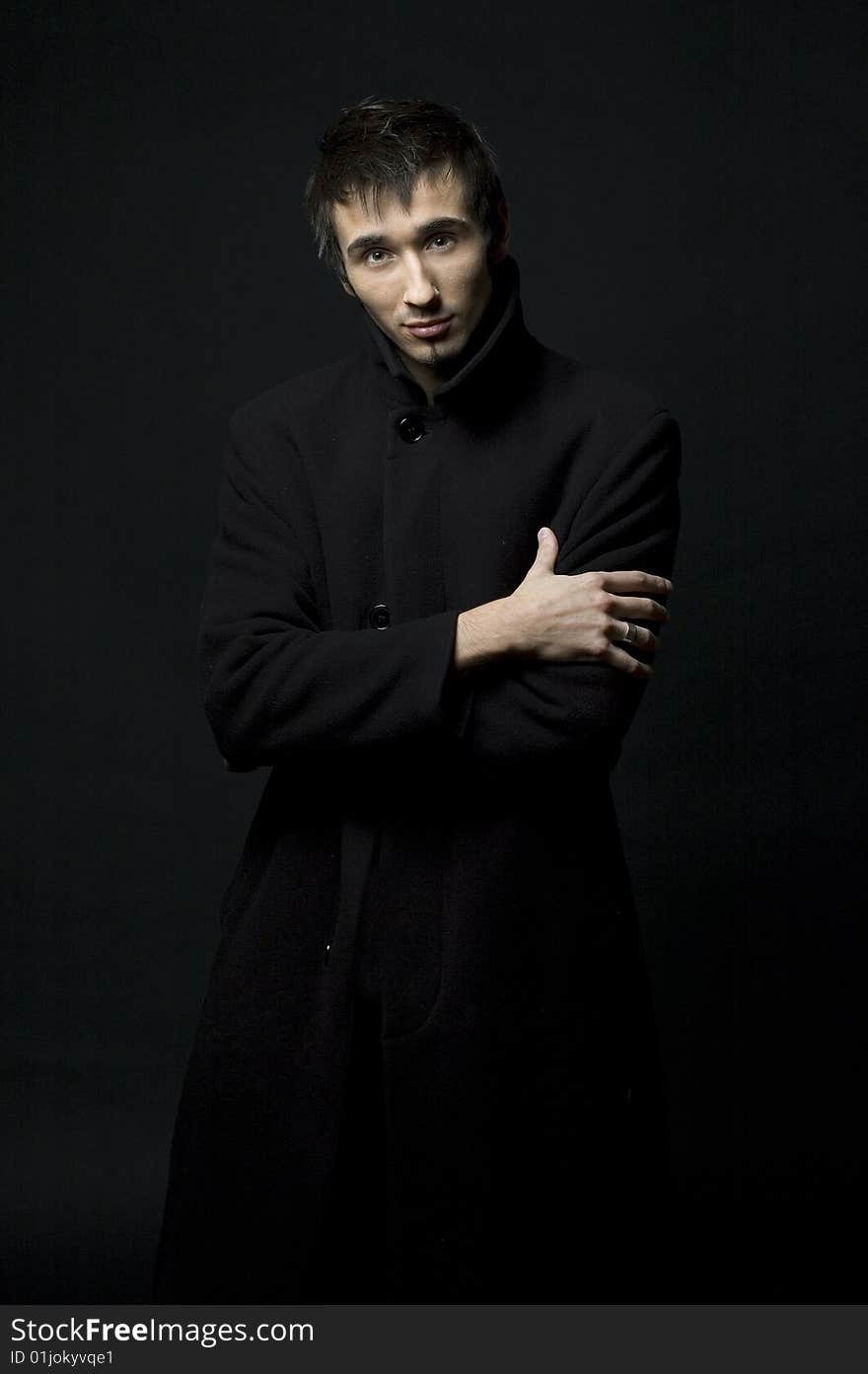 Portrait of a young business man with his hands on a dark background. Portrait of a young business man with his hands on a dark background