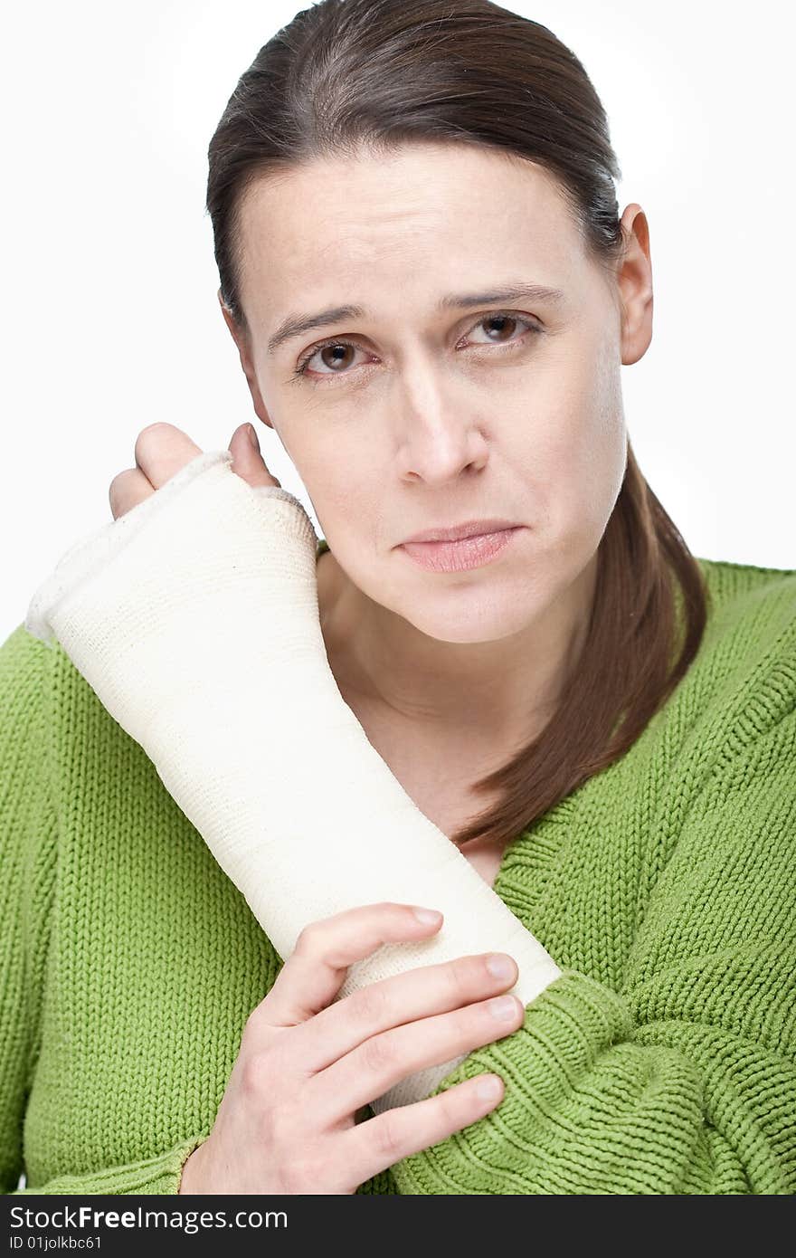 An upset woman with an arm injury on a white background