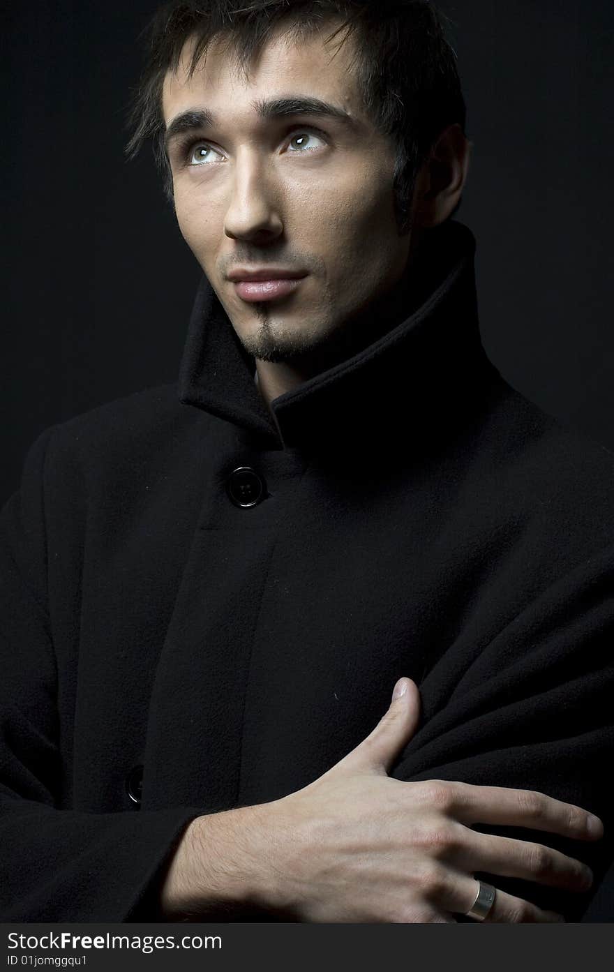 Portrait of a young business man with his hands on a dark background. Portrait of a young business man with his hands on a dark background